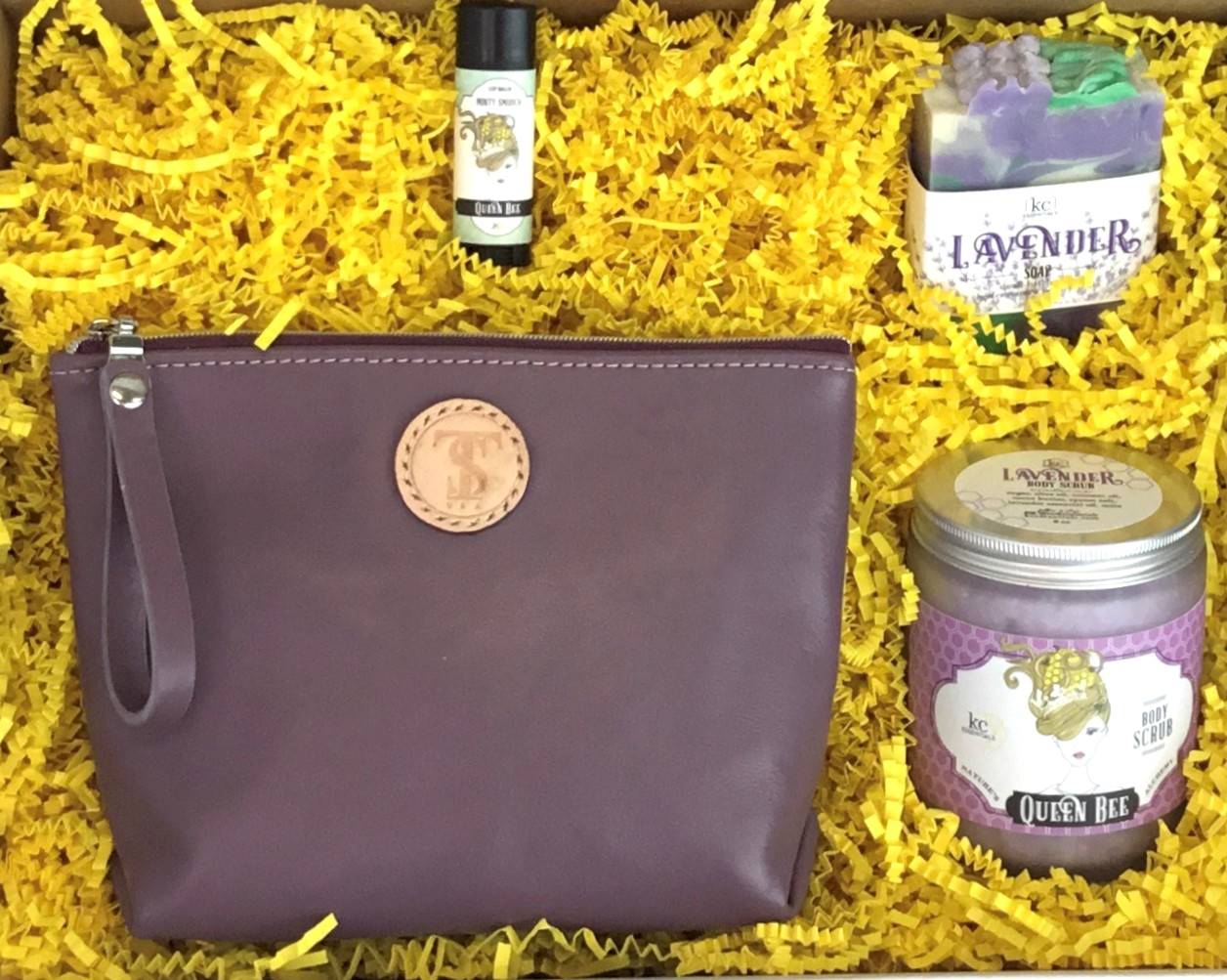 Town & Shore Handcrafted Serenity Gift set featuring T5 Leather bath kit and brush bag shown in Lavender purple calfskin leather. KC Essentials artisan made vegan bar soap, essential oils body scrub and soothing lip balm. Arranged in gift box with sustainable eco-friendly yellow crinkle paper.