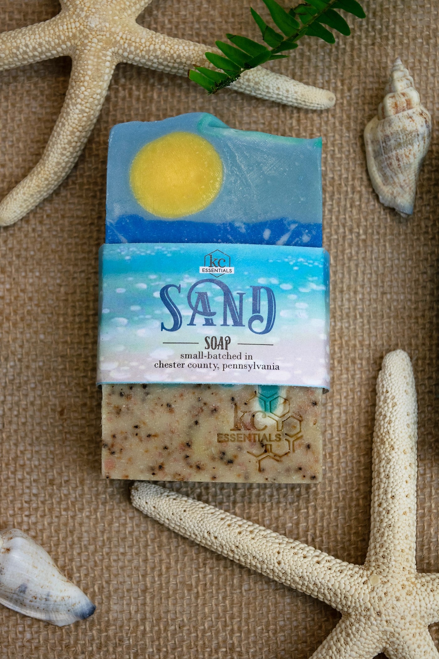 Artisan Bar Soap that shows a beach with sand surf and yellow sun high in the blue sky with wisps of clouds