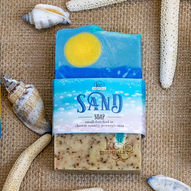 Artisan Bar Soap that shows a beach with sand surf and yellow sun high in the blue sky with wisps of clouds