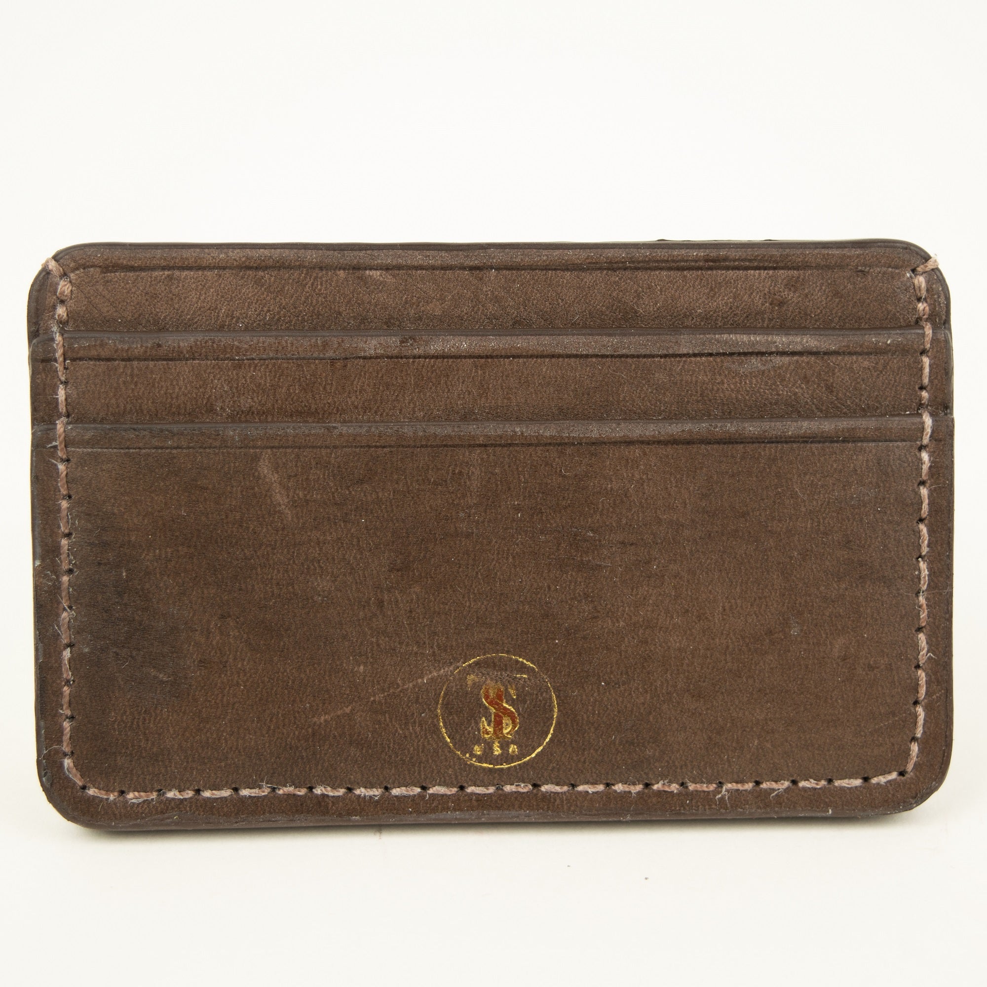 Front view of Distressed finish Chocolate brown leather slim card case with two front pockets center pocket gold brand logos on front