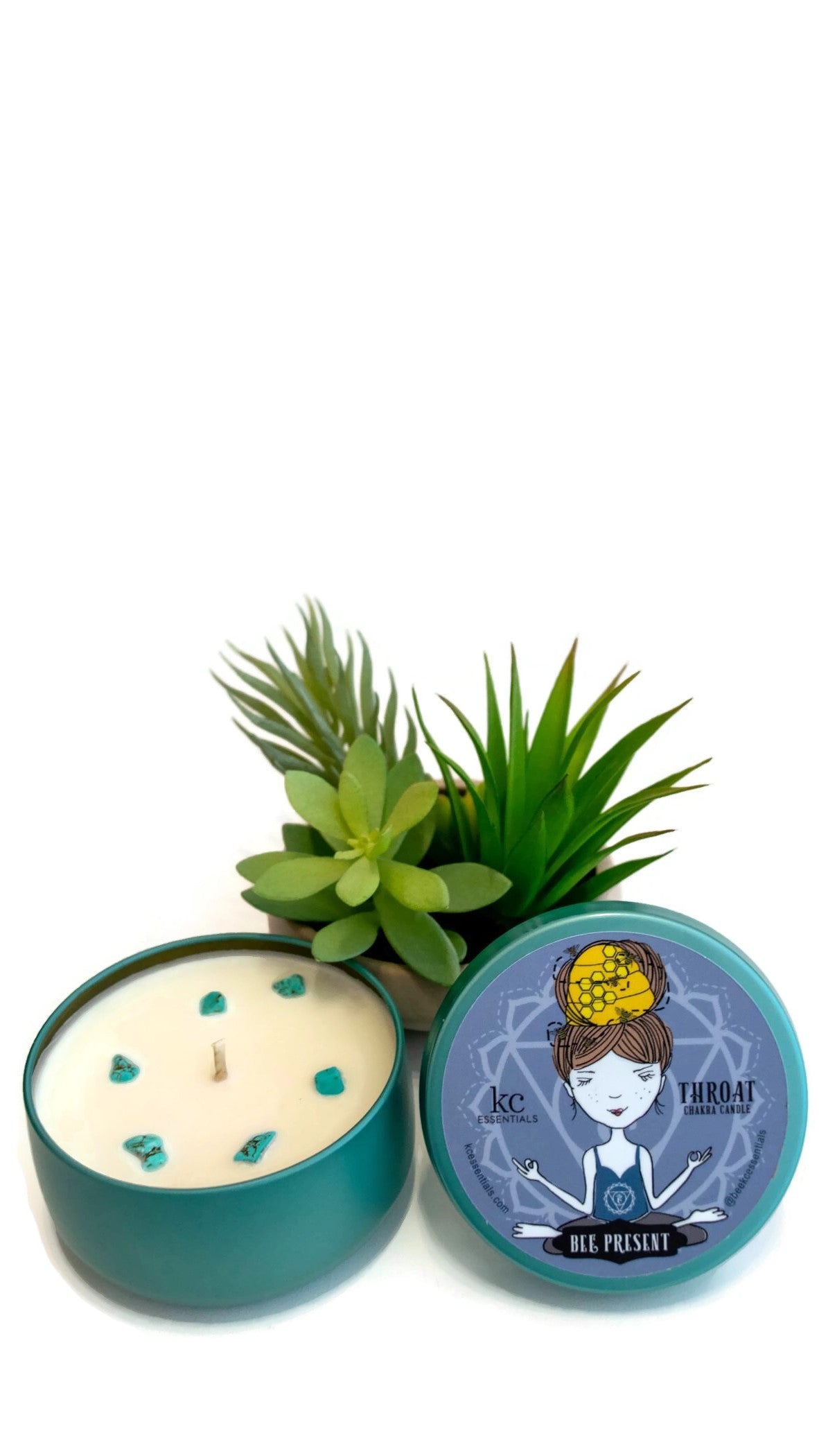 Small plant next to the Scented Throat Chakra Candle in shiny Turquoise colored Lidded Tin with Turquoise gemstones  in the soy wax. Lid shows a girl in a seated yoga pose
