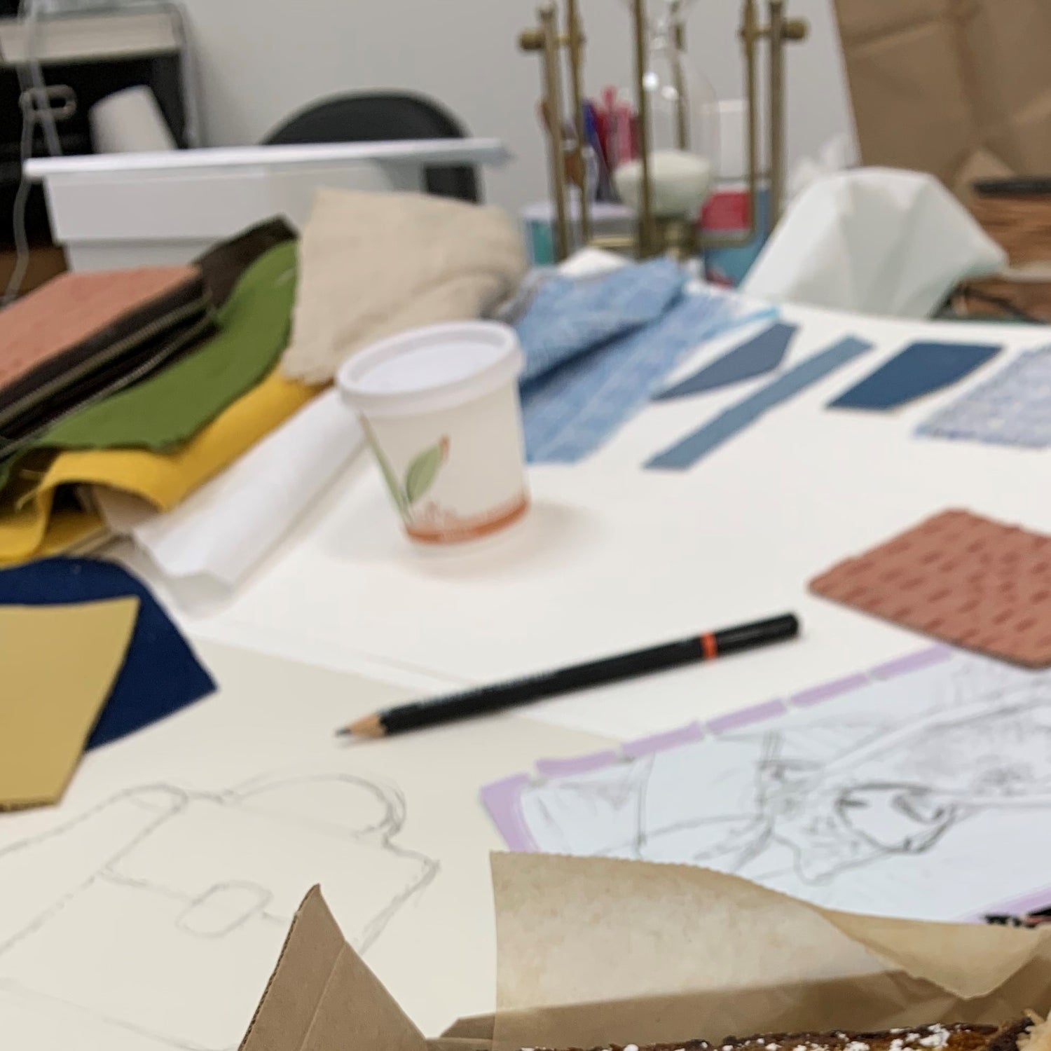view of fabric and leather swatches with pencil sketches of bag design
