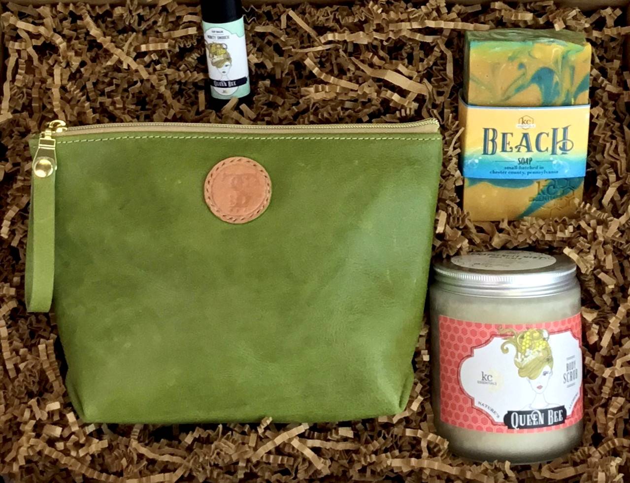 Town &amp; Shore Handcrafted Serenity Gift set featuring T5 Leather bath kit and brush bag shown in aloe green calfskin leather. KC Essentials artisan made vegan bar soap, essential oils body scrub and soothing lip balm. Arranged in gift box with sustainable eco-friendly craft crinkle paper.