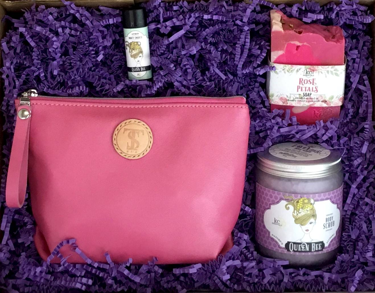 Town &amp; Shore Handcrafted Serenity Gift set featuring T5 Leather bath kit and brush bag shown in baby pink calfskin leather. KC Essentials artisan made vegan bar soap, essential oils body scrub and soothing lip balm. Arranged in gift box with sustainable eco-friendly purple crinkle paper.