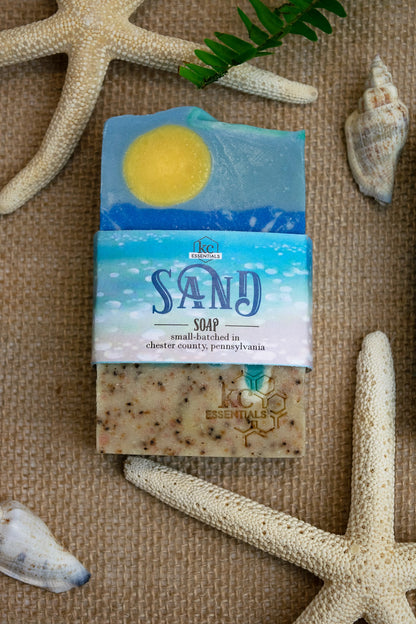 Artisan Bar Soap that shows a beach with sand surf and yellow sun high in the blue sky with wisps of clouds