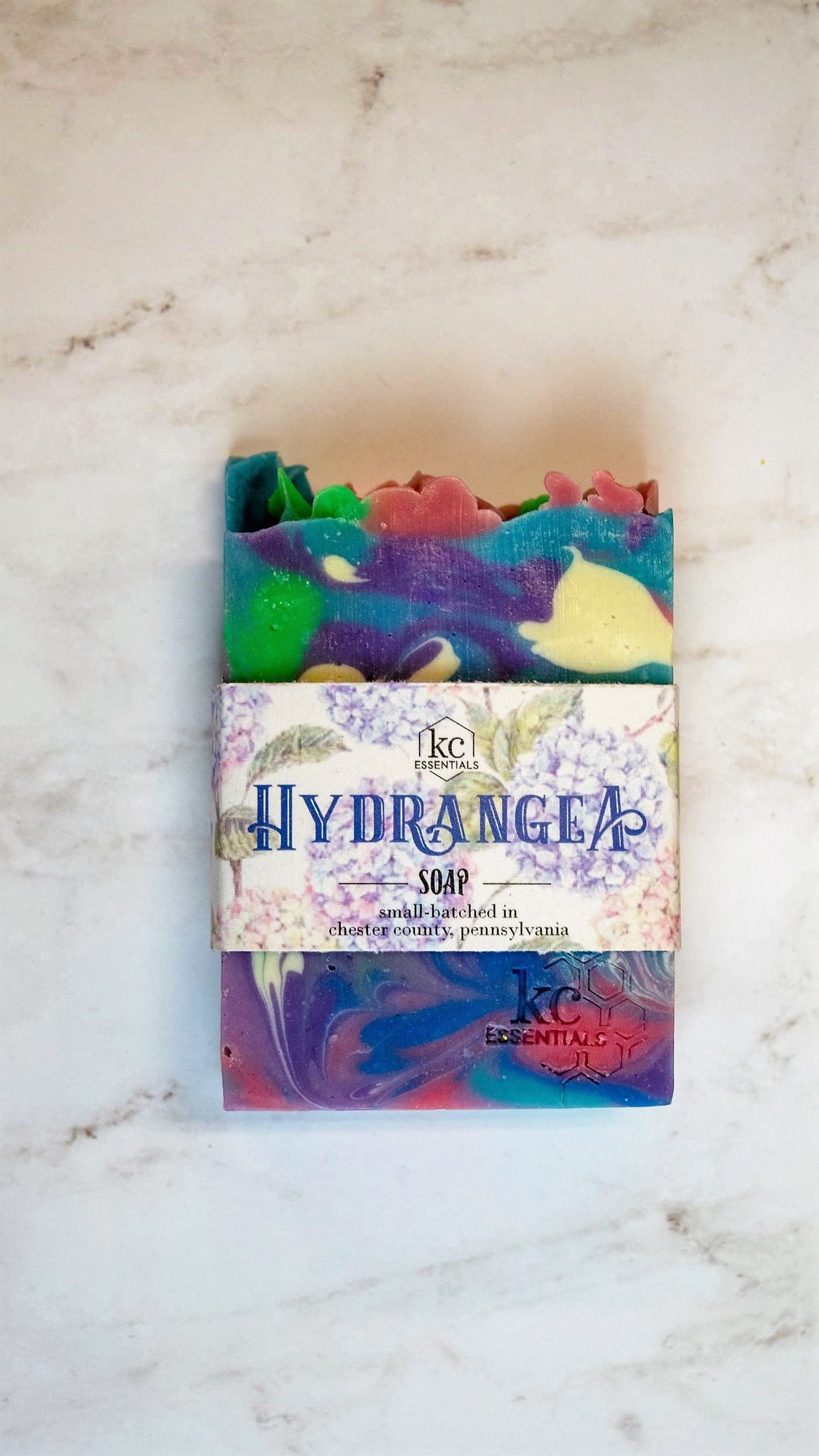 Swirls of purple, pink, white, blue and green in the artisan soap bar.