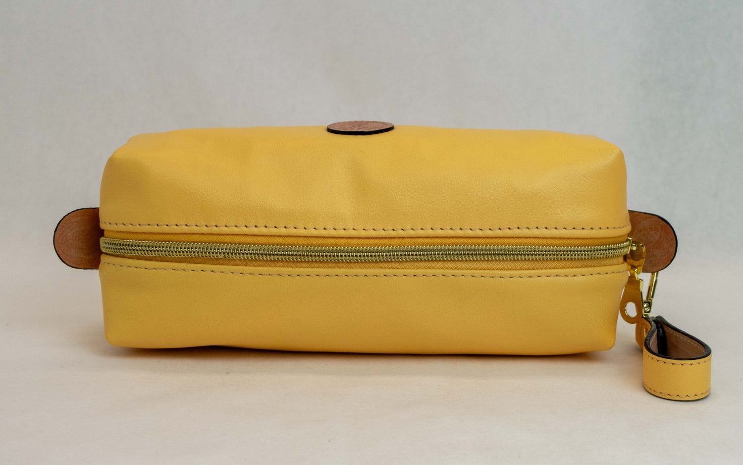Top view of T5 bath dopp kit toiletry wash bag designer handcrafted of smooth calf leather in saffron yellow.