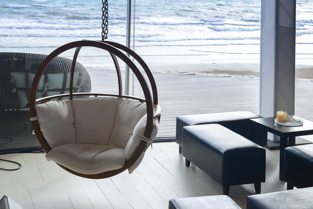 Hanging wood egg chair in beauty house beside the sea