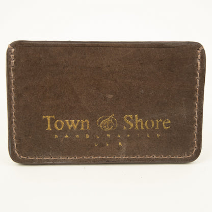 Back view of Distressed finish Chocolate brown leather slim card case with two front pockets center pocket gold brand logos on back 