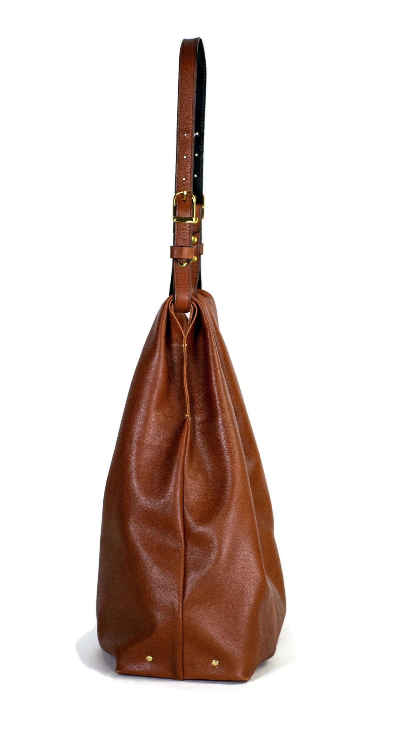 Side of Cognac brown leather hobo shoulder bag handcrafted in Italian calfskin by slow fashion indie designer Liv McClintock. Made in Wilmington Delaware USA.